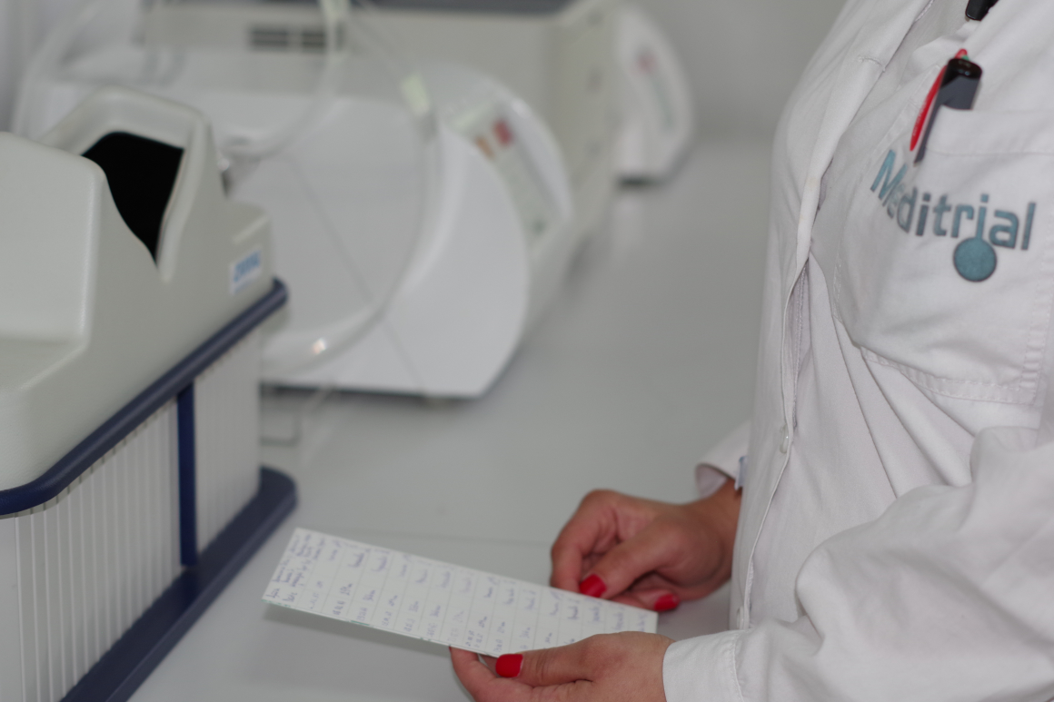 Laboratory work at Meditrial, with a branded lab coat and analytical equipment